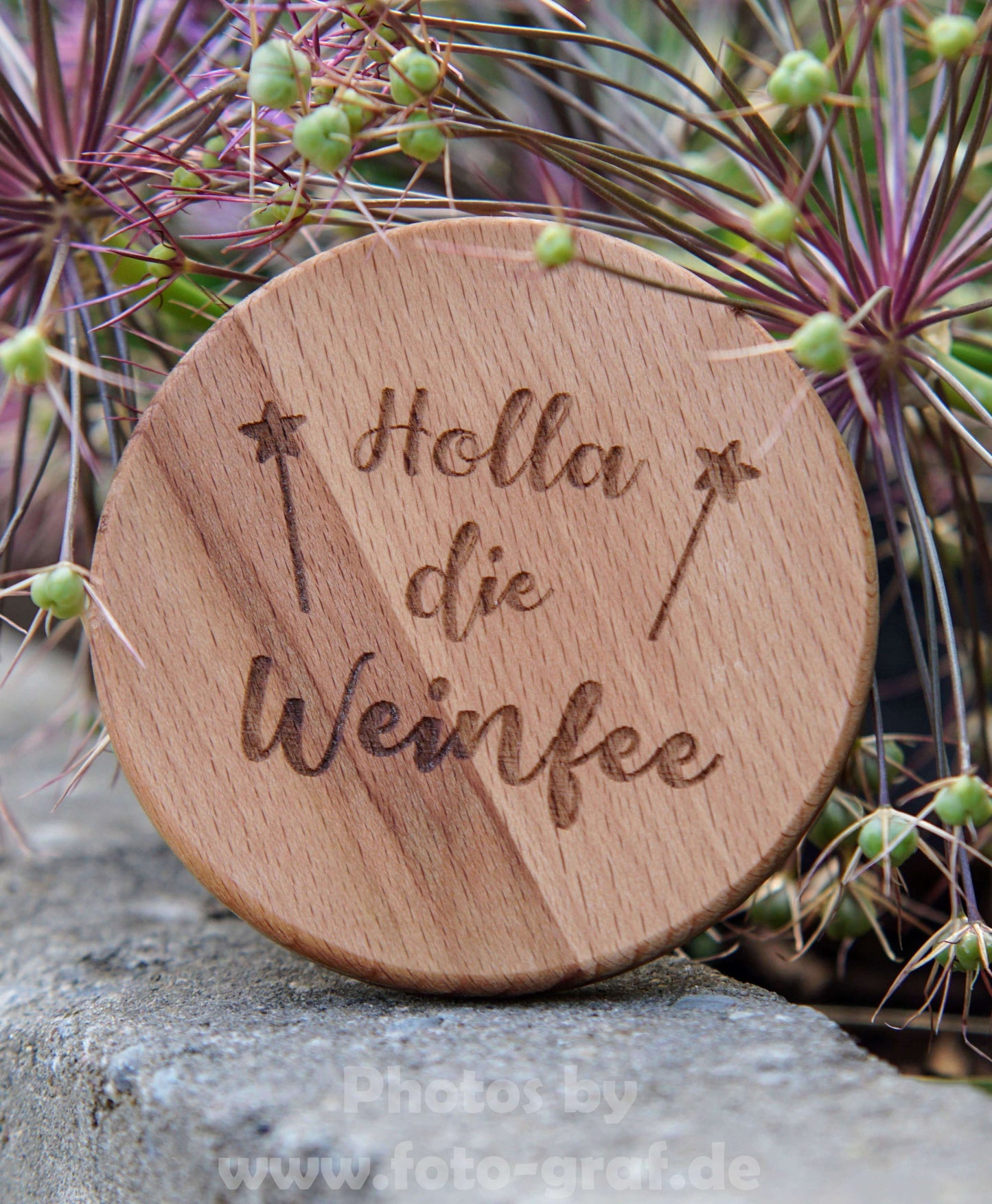 Stylish wooden lid with 'Holla die Weinfee' engraving, perfect for a 0.5L Dubbeglas, surrounded by greenery.